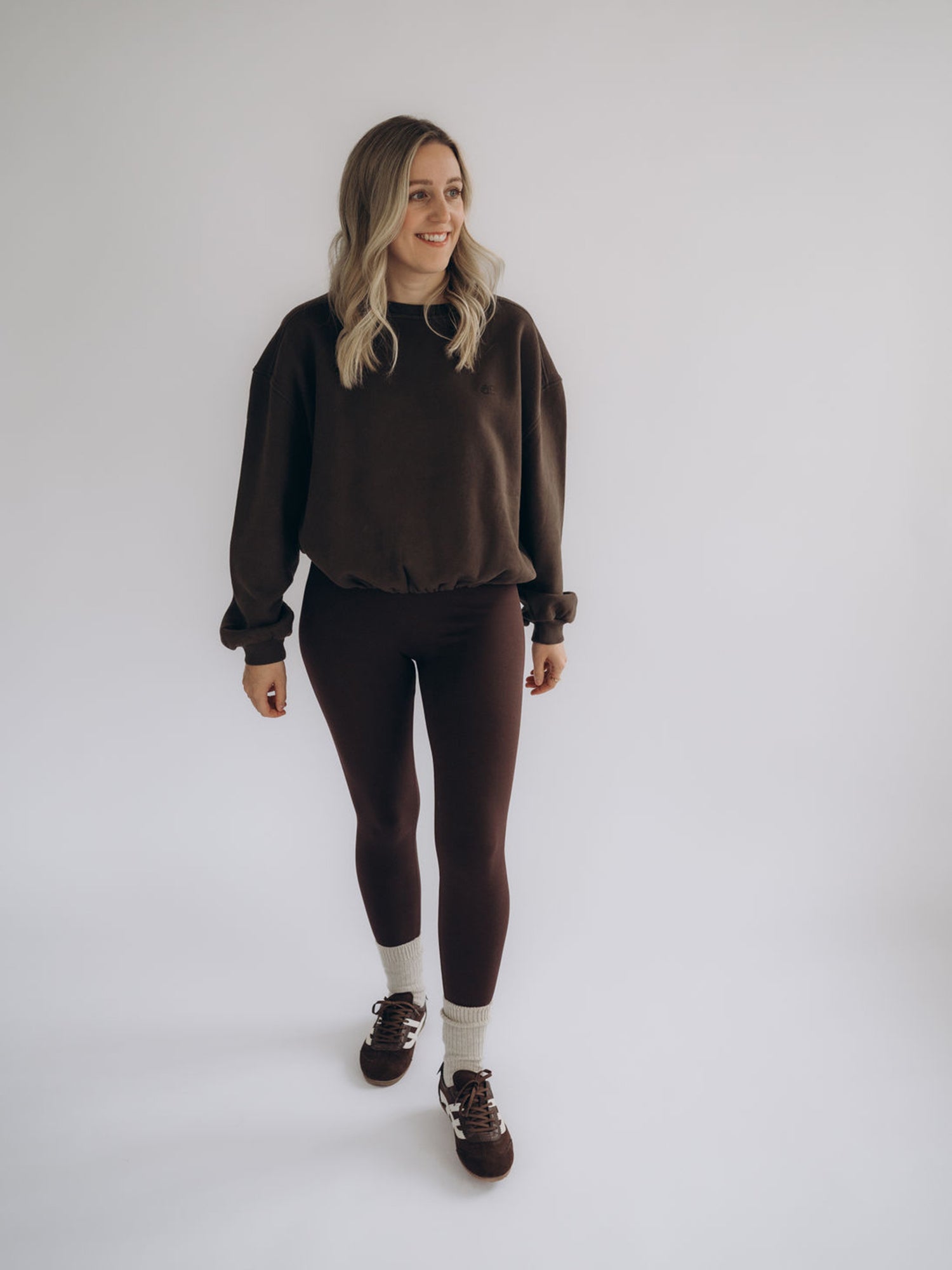 Michi trägt die dunkelbraune Leggings MONA in einer frontalen Ganzkörperansicht.