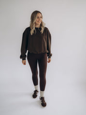 Michi trägt die dunkelbraune Leggings MONA in einer frontalen Ganzkörperansicht.