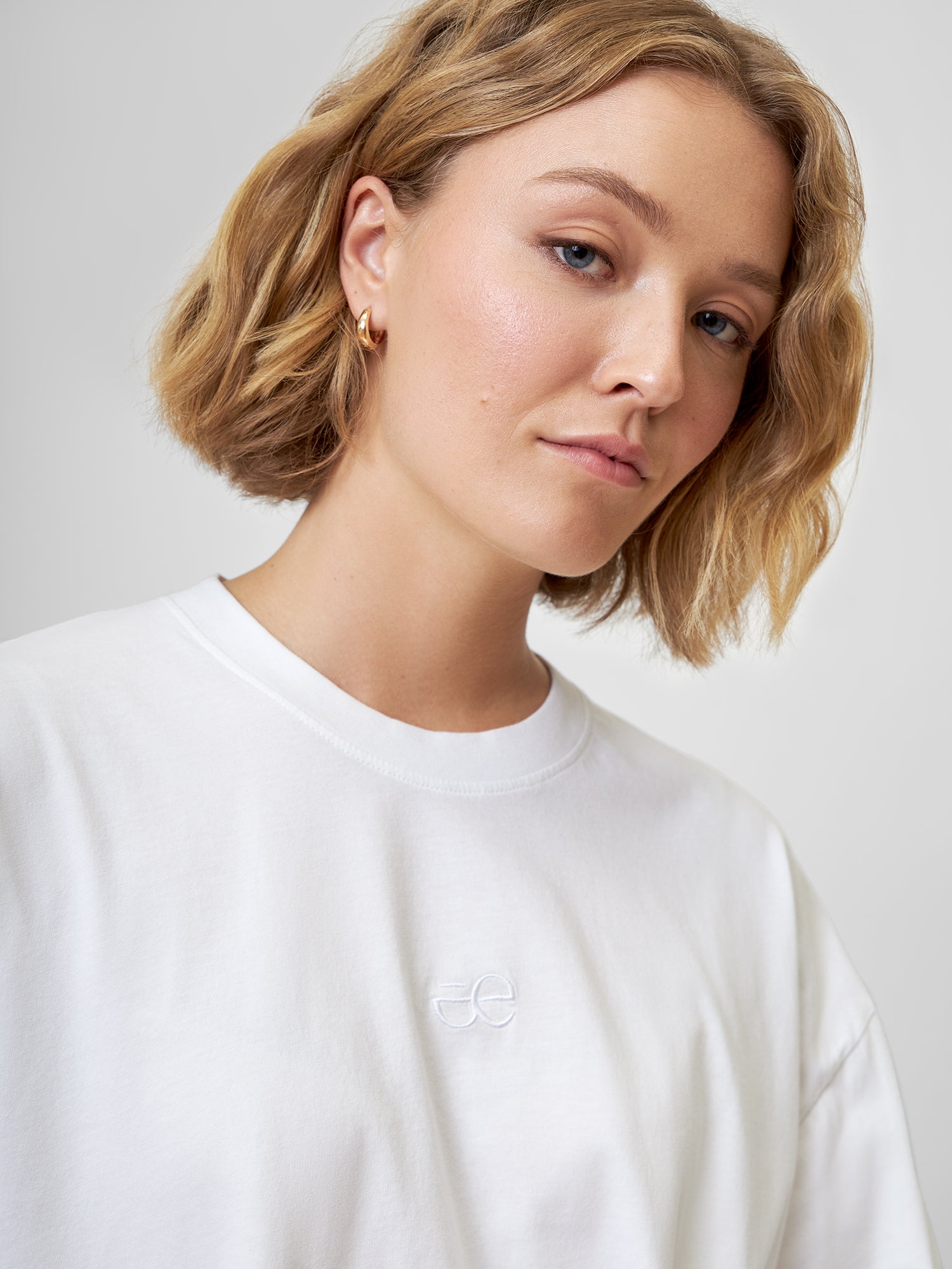 Nahaufnahme Longsleeve CARLOTTA mit weißem gesticktem everless Logo und Barrell-Jeans BARELLAA