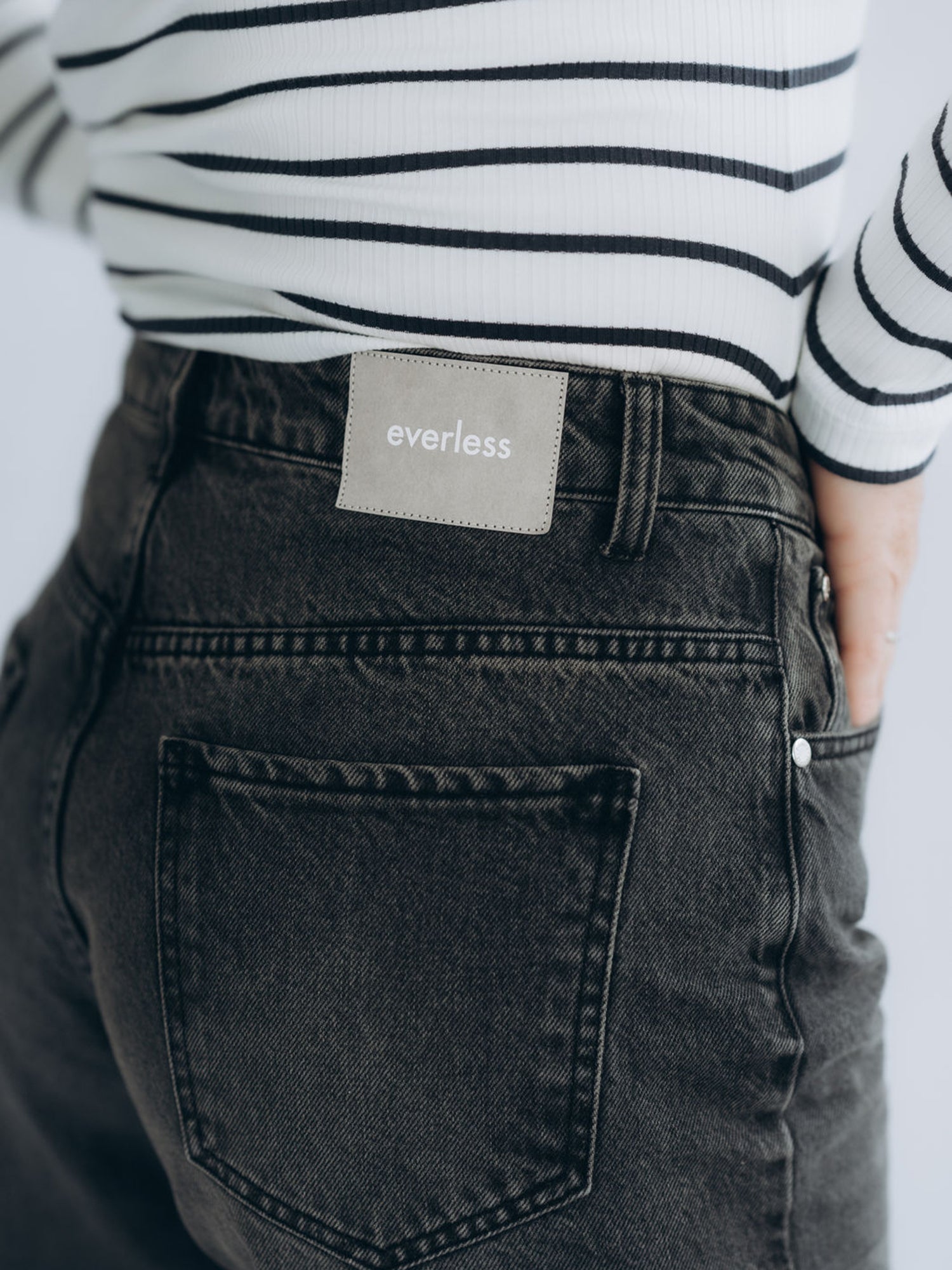 Rückwärtige Detailaufnahme mit aufgesetzten Gesäßtaschen und Markenpatch am Bund