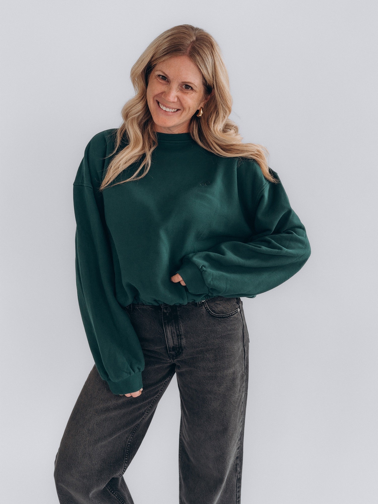 Angi trägt LAURA 2.0 von vorn zu einer dunkelgrauen Jeans; der lockere, verkürzte Schnitt ist gut sichtbar.
