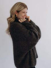 Seitliche Nahaufnahme von TILDA mit flauschigem Strickbild und voluminöser Ärmelpartie.